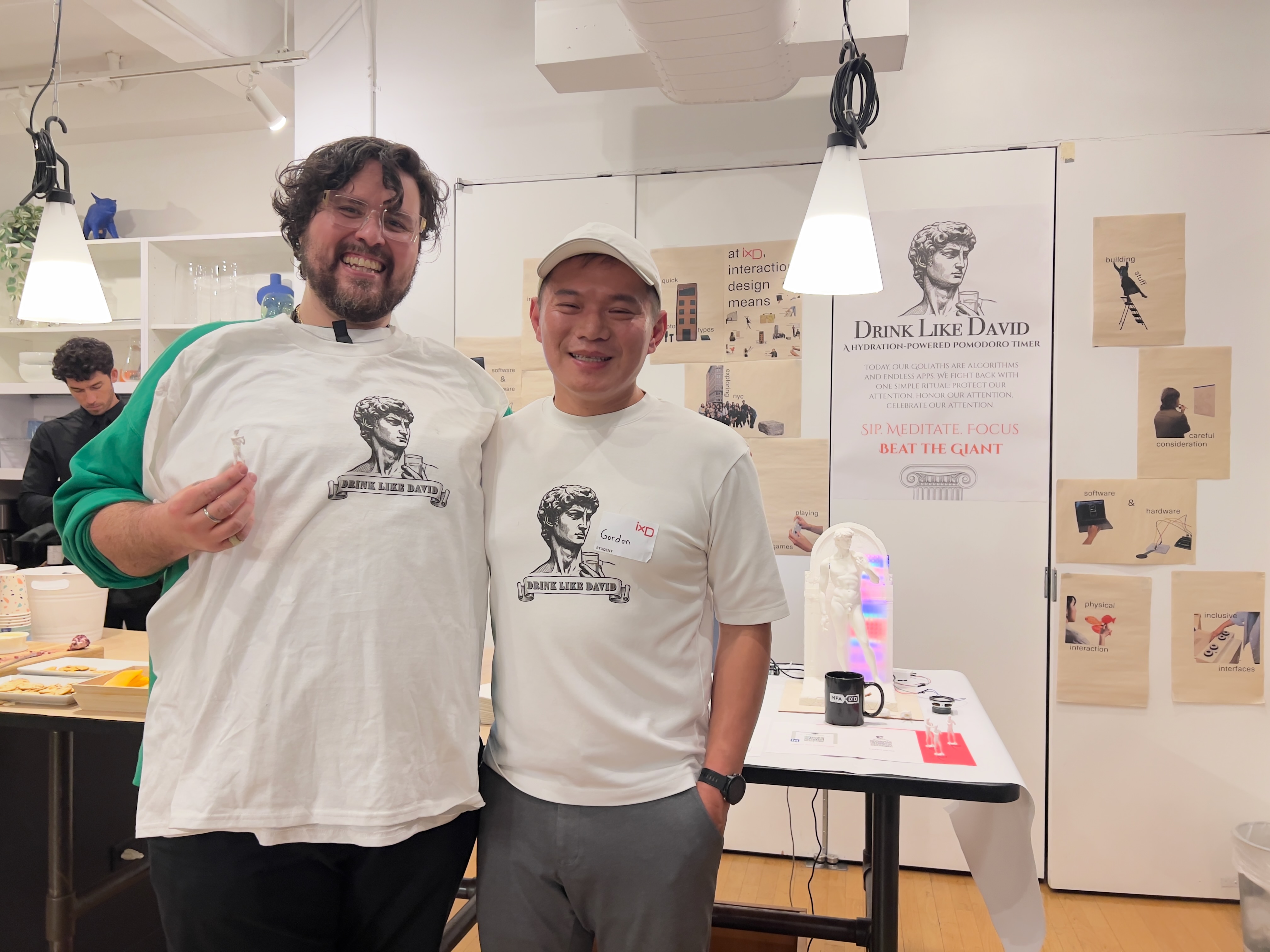 Gordon with instructor wearing Drink Like David T-shirts at exhibition
